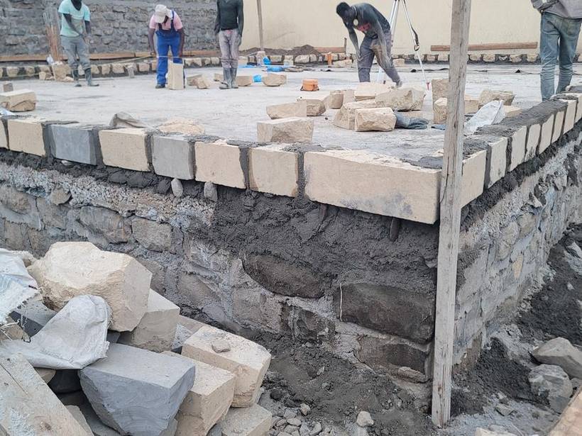 Machine-cut stone walling under construction