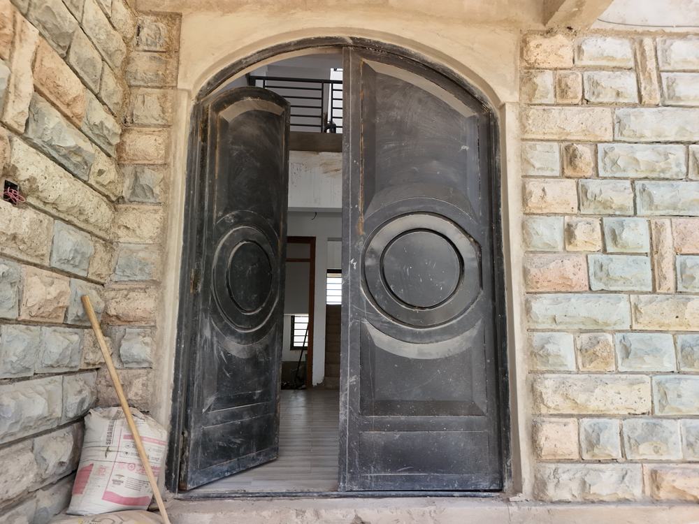 Arched steel entrance doors in a stone facade
